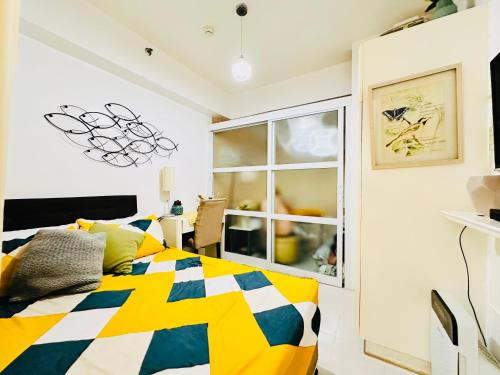 a bedroom with a colorful bed and a window at Tagaytay Staycation - Casa Editha in Tagaytay
