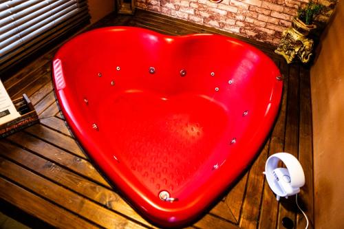 a red heart shaped object sitting on a wooden floor at Pousada Recanto do Aconchego in Florianópolis