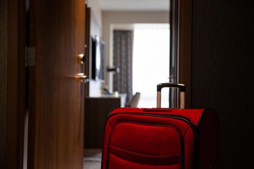 a red suitcase is sitting in a room at The Landing Hotel at Rivers Casino Pittsburgh in Pittsburgh