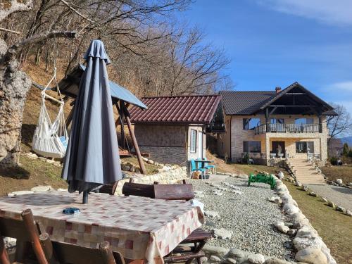 an umbrella sitting on a table in front of a house at Dumbrava Ursului in Zărneşti