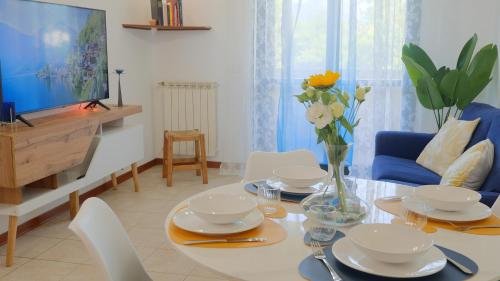 ein Wohnzimmer mit einem Tisch und einem blauen Sofa in der Unterkunft Appartamento [Golden Hour] Marina di Pietrasanta in Marina di Pietrasanta