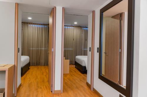 a room with two beds and two doors to a bedroom at Hotel Casino Internacional in Cúcuta