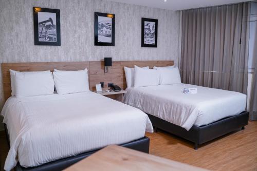 a hotel room with two beds and a table at Hotel Casino Internacional in Cúcuta