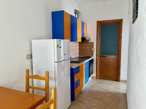a kitchen with a white refrigerator and blue cabinets at Redi's Seaview Apartments in Sarandë