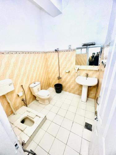 a bathroom with a toilet and a sink at Paradise Rain Hotel in Garhn