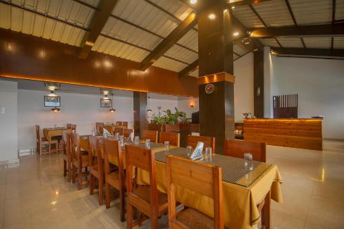 ガントクにあるPalri Boutique Hotelのレストラン内のテーブルと椅子のあるダイニングルーム