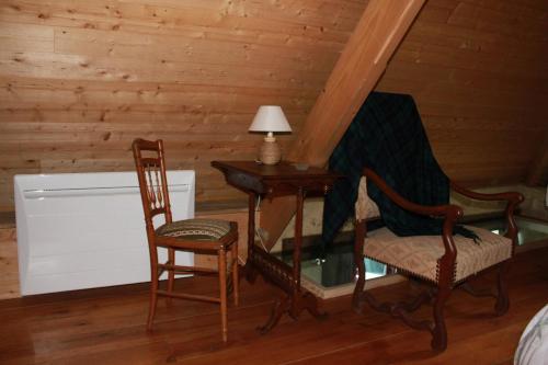 a room with a desk and two chairs and a lamp at Gîte semi-troglodytique du Vieux Chai de Trôo in Trôo
