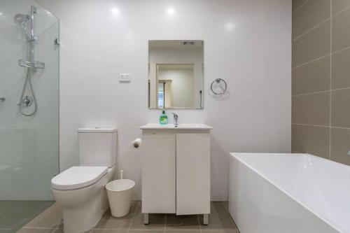 a bathroom with a toilet and a sink and a tub at Close to everything Family Friend 2 Free Parking in Sydney