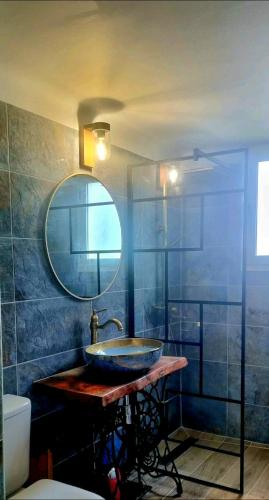 une salle de bain avec un lavabo et un miroir dans l'établissement Le Pigeonnier, à Vaison-la-Romaine