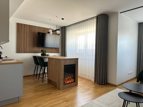 a living room with a fireplace and a table at RG Kanali Apartment in Pärnu