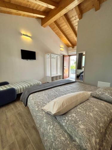 a bedroom with a bed and a tv on the wall at Locanda B&B Da Nati in Arba