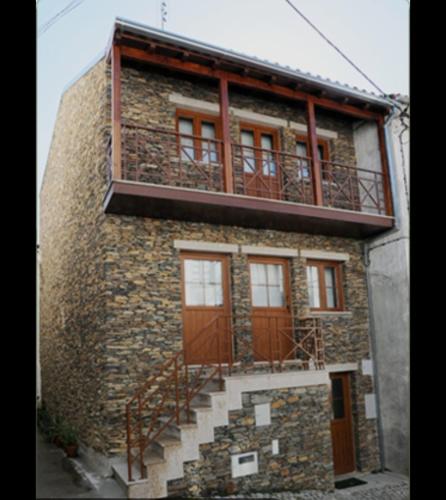 a brick building with a balcony on top of it at Latada Suit's Serra da Estrela in Sameiro