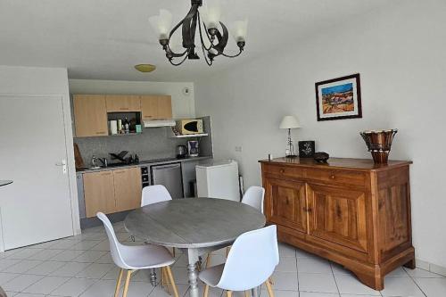 une cuisine et une salle à manger avec une table et des chaises dans l'établissement Appartement solaire duplex avec terrasse en bois, à Pessac