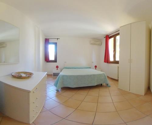 een slaapkamer met een bed in een witte kamer bij Domus Liscia di Vacca in Liscia di Vacca