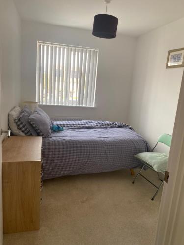 a bedroom with a bed and a window and a chair at Torias Place - Lenham in Maidstone