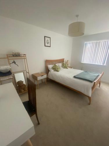 a bedroom with a bed and a table in it at Torias Place - Lenham in Maidstone