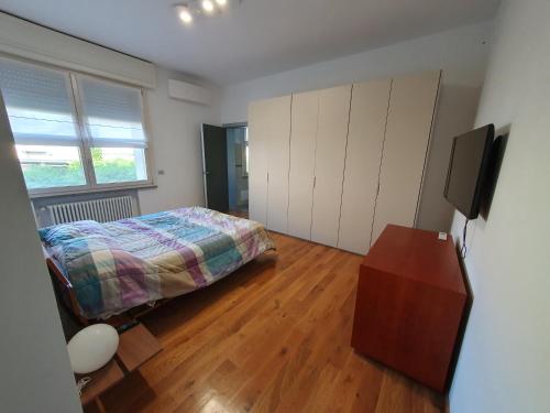 ein Schlafzimmer mit einem Bett und einem TV in der Unterkunft B&B Cremonese in Parma