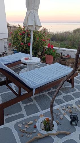 a wooden bed sitting on a patio with an umbrella at Smaragda home in Liaropá