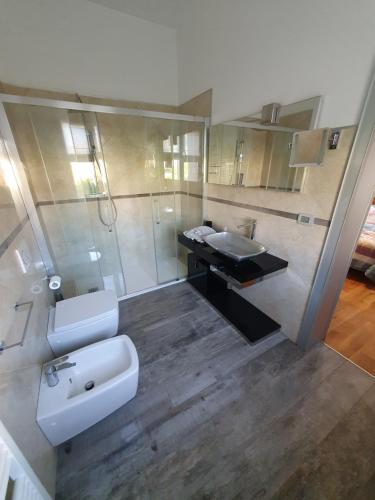 bagno con lavandino, servizi igienici e specchio di B&B Cremonese a Parma