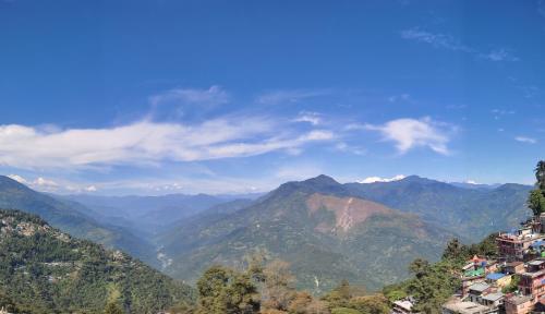 a view of a mountain range with houses at Hotel Orchid in Kalimpong