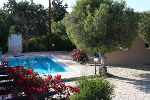 a swimming pool in a yard with flowers at Villa Barbara in Dhrápanos