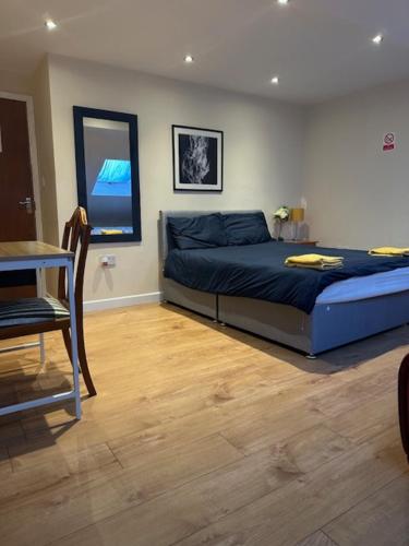 um quarto com uma cama, uma mesa e uma cadeira em Luton Town House Near AIRPORT em Luton