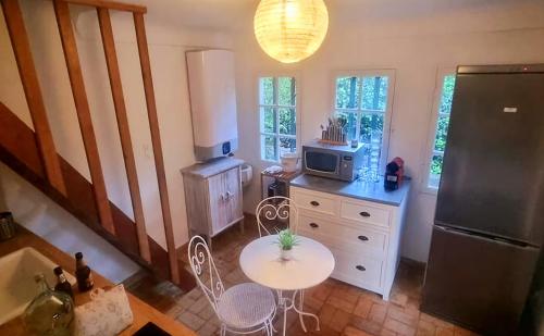 an overhead view of a kitchen with a table and a refrigerator at Le Pigeonnier in Vaison-la-Romaine