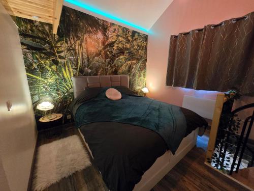 a bedroom with a black bed with a painting on the wall at Suite Love et Evasion in Saint-André-le-Gaz
