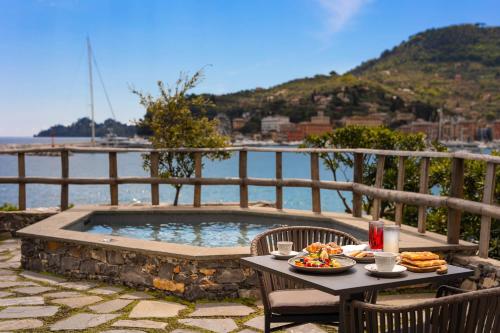 a table with a plate of food next to a pool at Hotel Continental in Santa Margherita Ligure