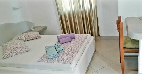 a white bed with two bags on top of it at Avgerinou Studios in Paliochori
