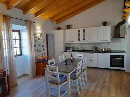 a kitchen with a table and chairs in a room at Casa Martins in Barão de São João