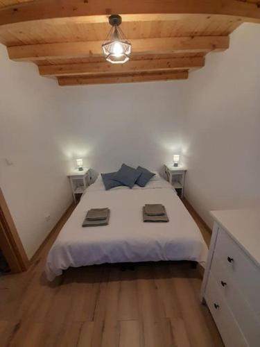 a bedroom with a large white bed with two tables at Casa Martins in Barão de São João