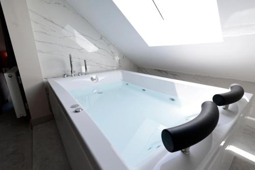 La salle de bains est pourvue d'une baignoire avec une chaise noire. dans l'établissement Livia Luxury Apart Hotel, à Antalya