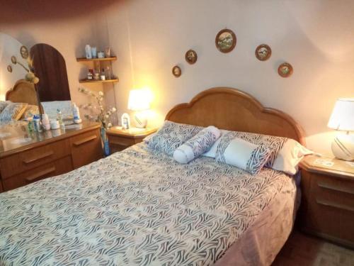 a bedroom with a bed and two tables and a mirror at Norma in Tandil