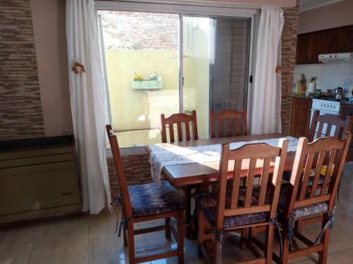 a dining room table with four chairs and a window at Norma in Tandil