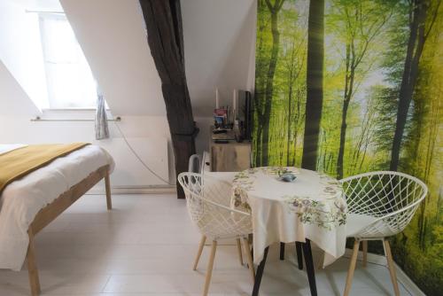 Zimmer mit einem Tisch, Stühlen und einem Fenster in der Unterkunft La Cascade et des Halles in Dijon