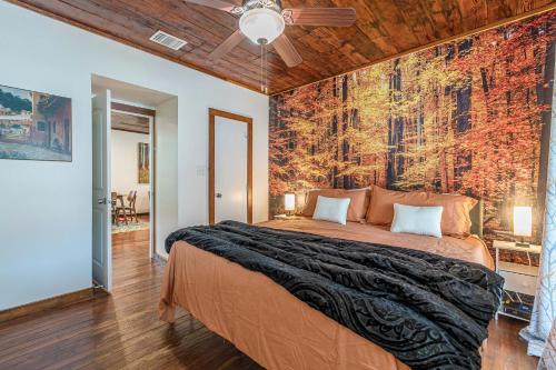 Un dormitorio con una cama grande con un mural de pared. en Free parking, Walk to Botanical Garden, PS4, Grill, Private fenced backyard, Pets allowed, en San Antonio