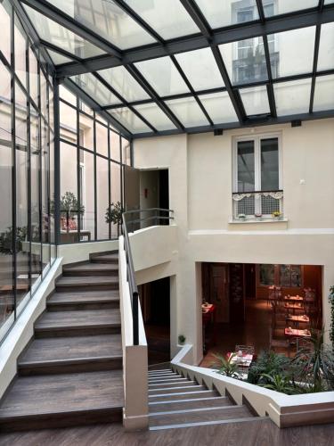 a staircase in a building with a glass ceiling at Hotel Moulin Plaza in Paris