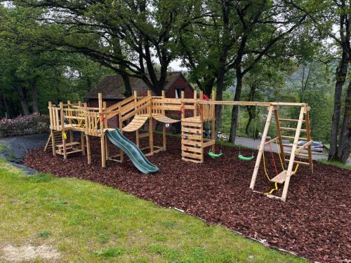 un parque infantil de madera con un tobogán y un columpio en Gites douillets à l’orée des bois., en Houyet