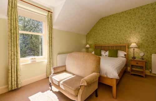a bedroom with a bed and a chair and a window at Burnside B&B in Keswick