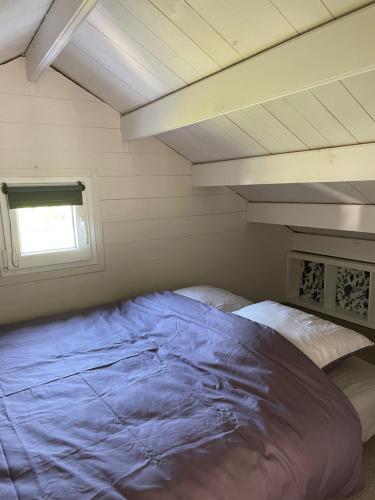 un grand lit dans une chambre avec une fenêtre dans l'établissement Le chalet de vacances, à Hermival-les-Vaux