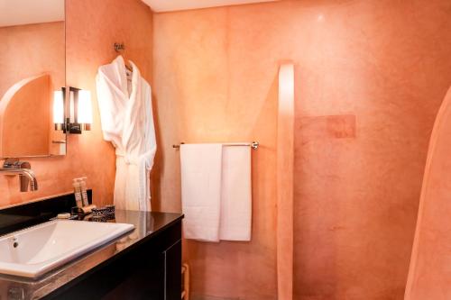 a bathroom with a sink and a mirror and a shower at Riad Al Ansari in Fez