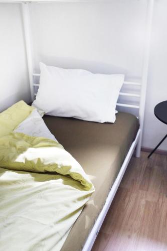 a bed with white sheets and a pillow on it at Fagrahlíd Guesthouse in Hvolsvöllur