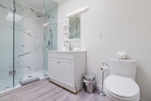 a white bathroom with a toilet and a shower at TheLongBeachResort - Beachfront Cottages & Townhouse Suites in Wainfleet
