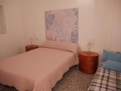 een slaapkamer met 2 bedden en 2 nachtkastjes bij Casa Voramar in Cullera