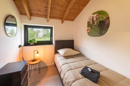 een kamer met een bed, een bureau en een raam bij Vakantiehuisje in de polder in Oud-Alblas