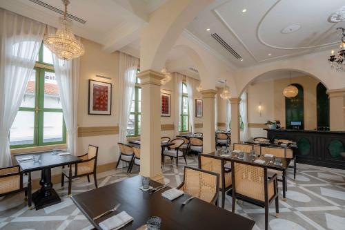 Un restaurante con mesas y sillas y una lámpara de araña. en Souphattra Heritage Vientiane, en Vientiane