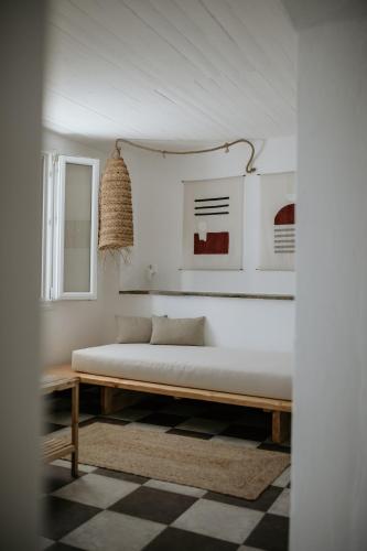 a bed in a room with white walls at Yi & Thalassa Living by KHI in Kithnos