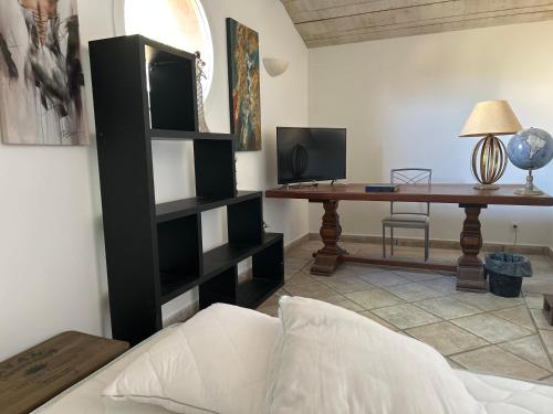 - un salon avec une étagère noire et un bureau dans l'établissement Maison de charme en bord de mer, à Lucciana