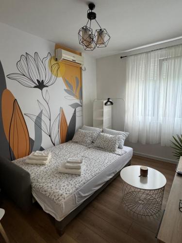 a bedroom with a bed with a flower mural on the wall at Eleven in Podgorica